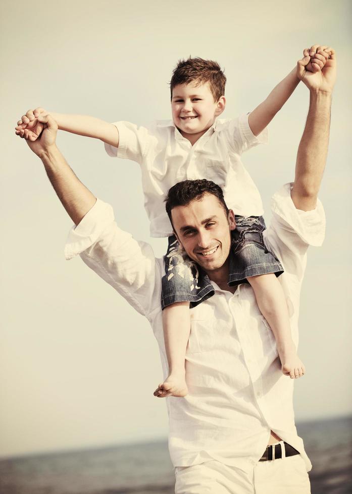 happy father and son have fun and enjoy time on beach photo