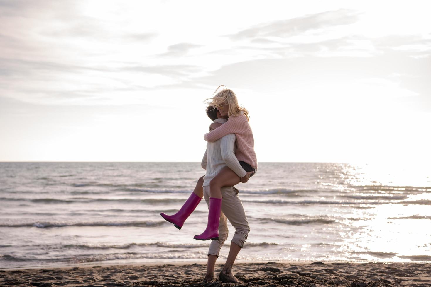 Loving young couple on a beach at autumn sunny day photo