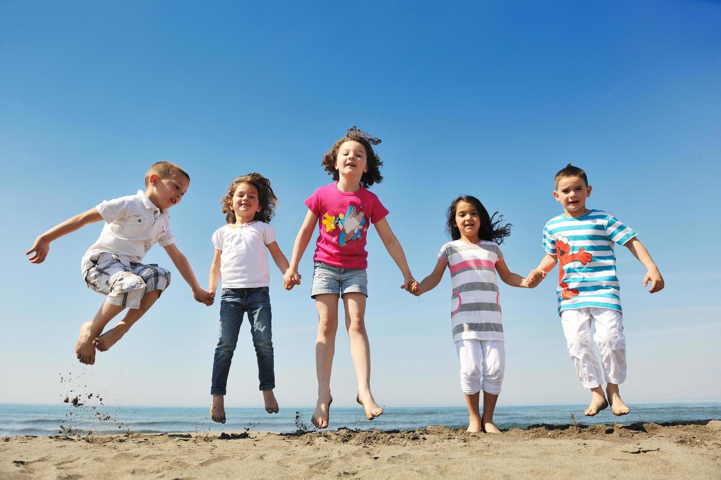 happy child group playing  on beach photo