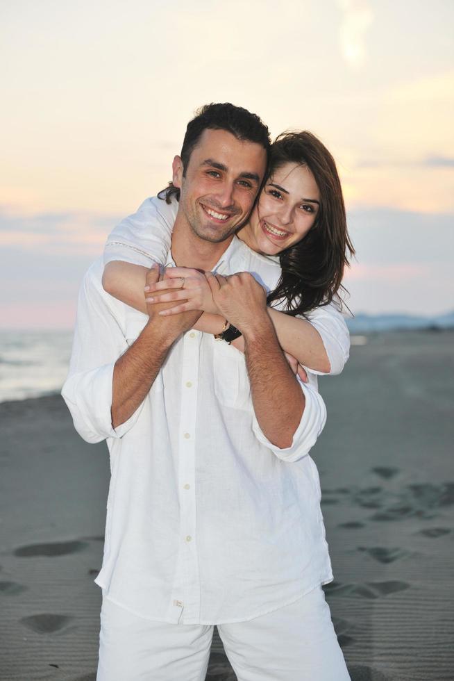 feliz pareja joven divertirse en la playa foto