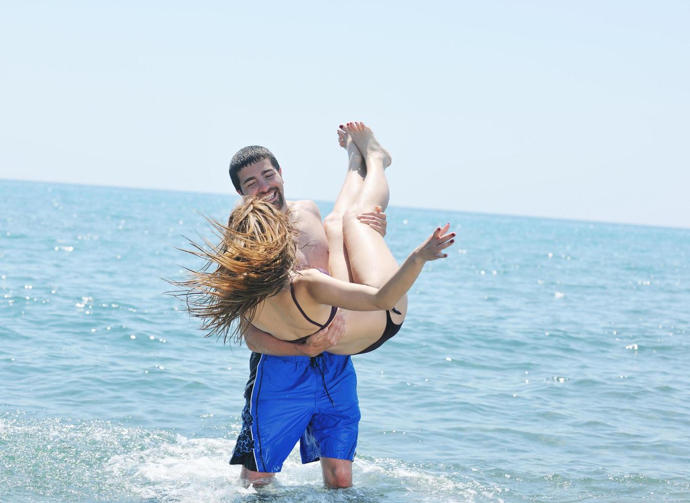 happy young couple have romantic time on beach photo