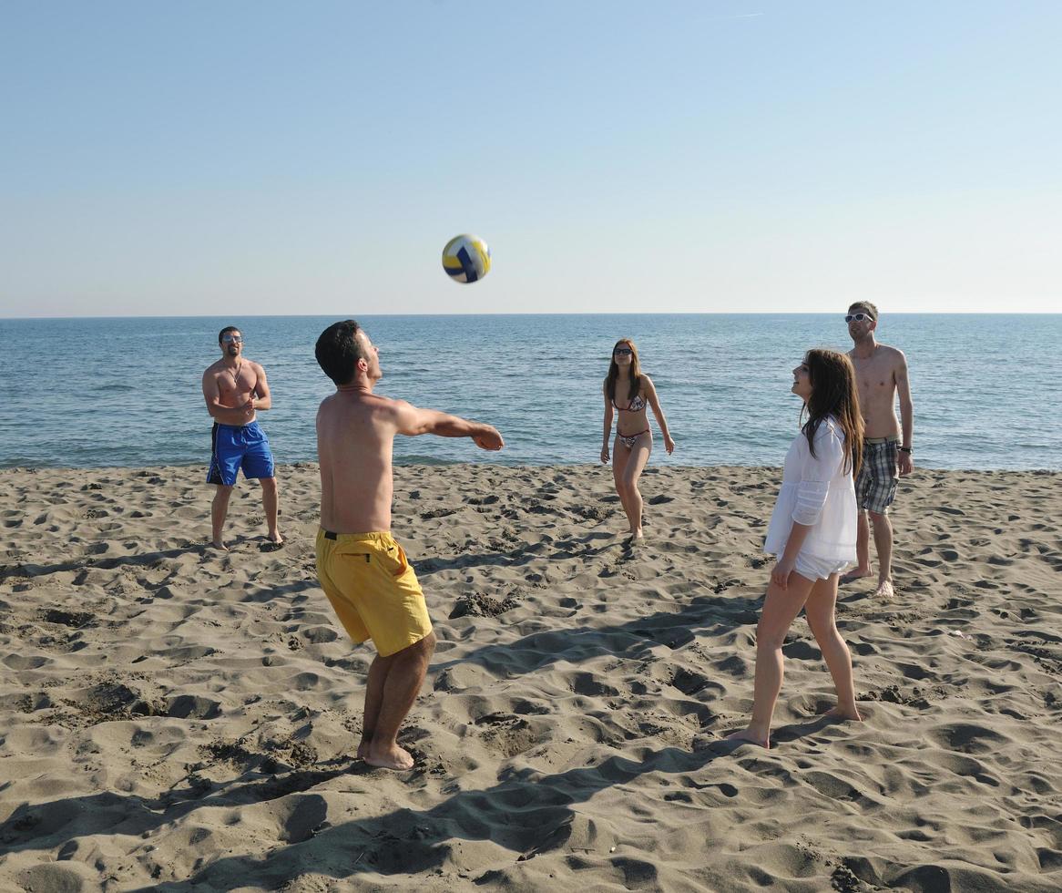 young people group have fun and play beach volleyball photo