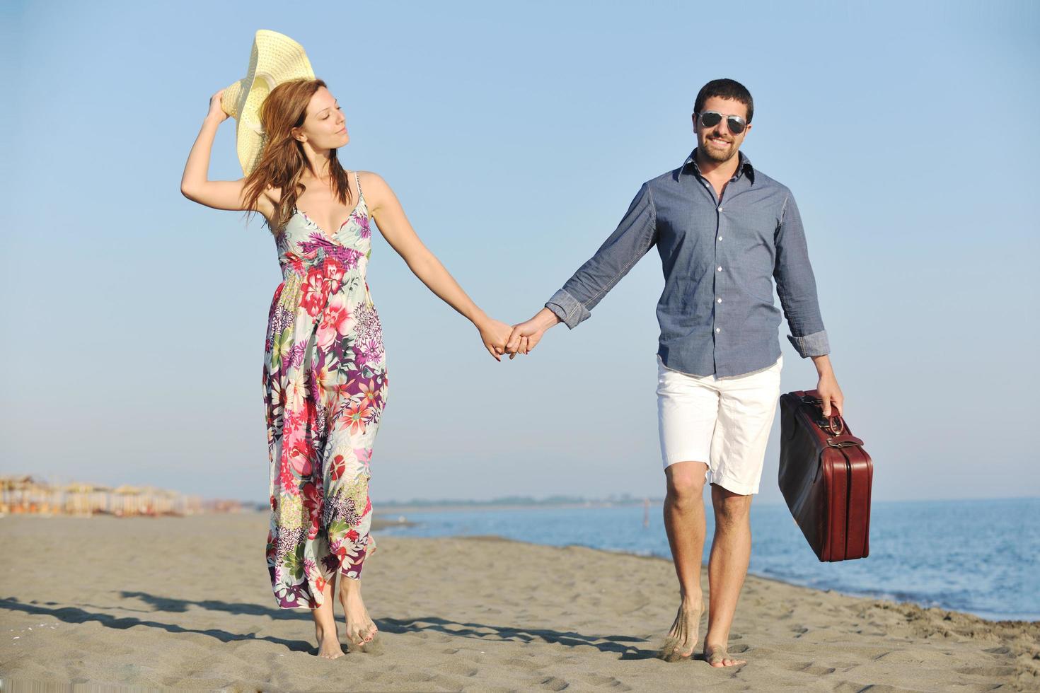 couple on beach with travel bag photo