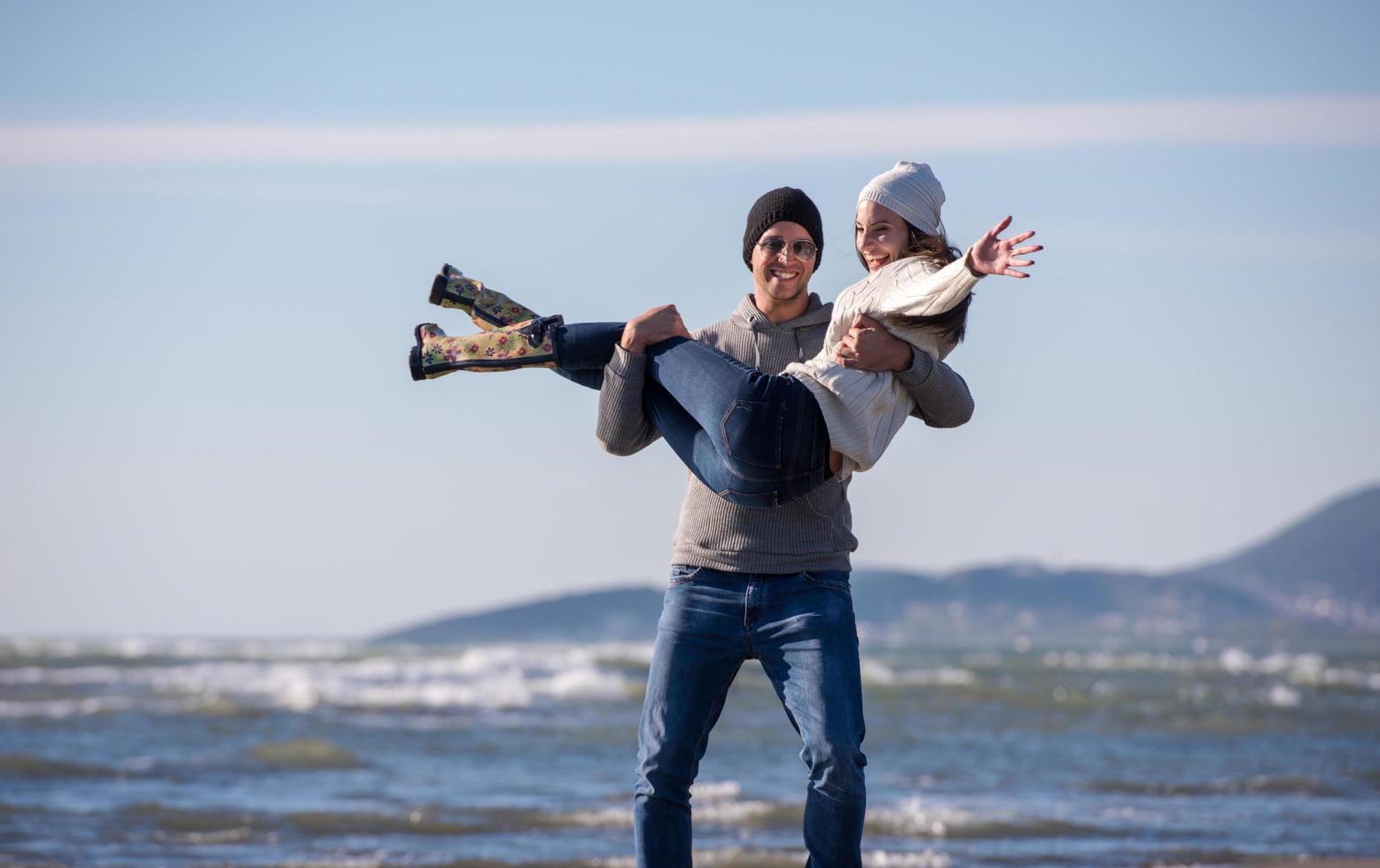 Loving young couple on a beach at autumn sunny day photo