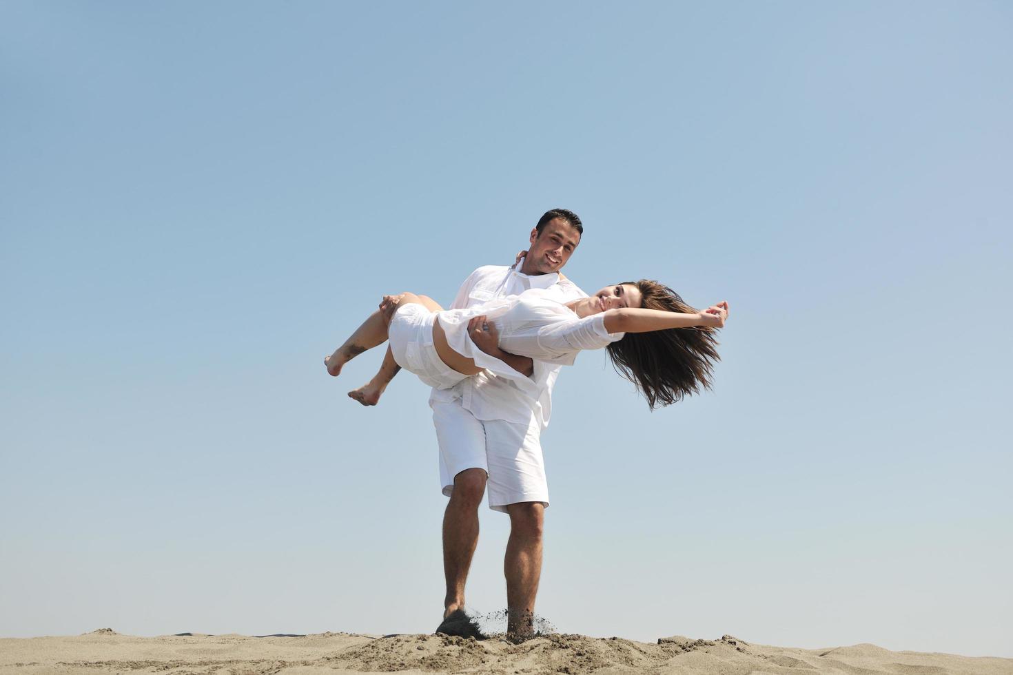 happy young couple have fun on beach photo