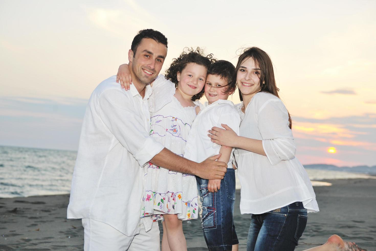 familia joven feliz divertirse en la playa foto