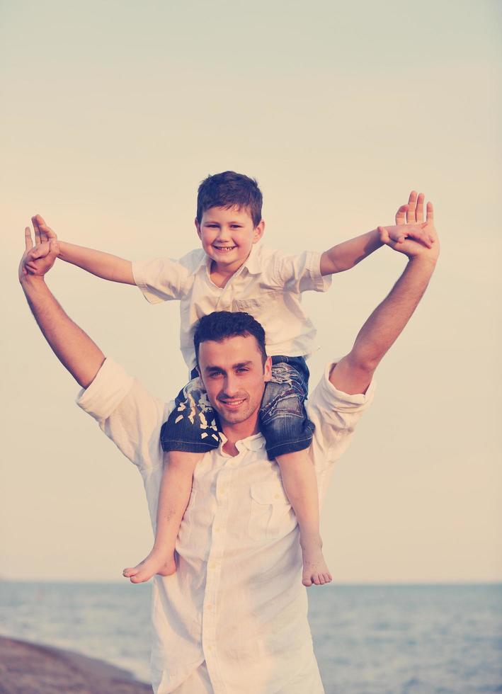 familia joven feliz divertirse en la playa foto