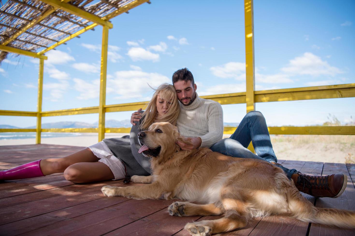 Couple with dog enjoying time on beach photo