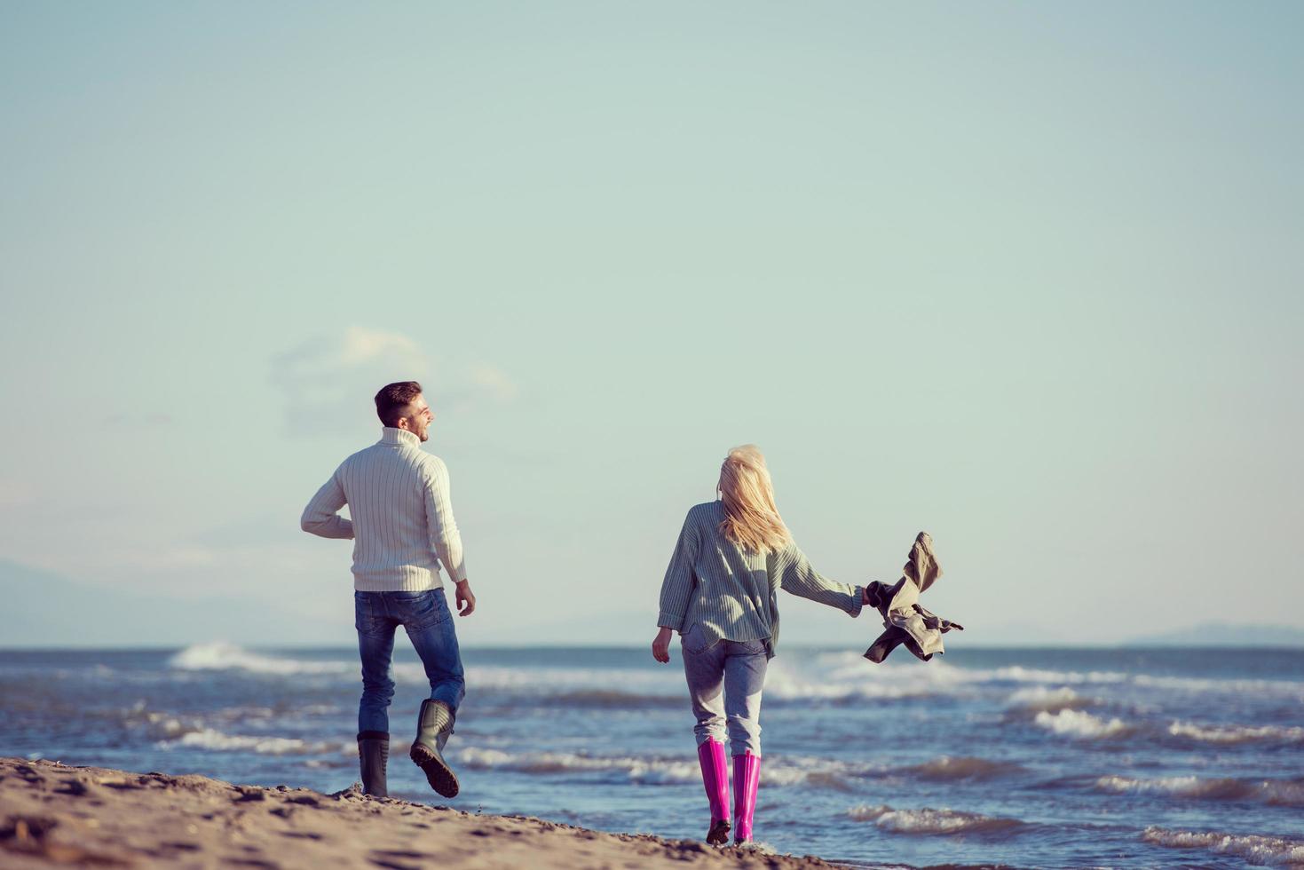 Loving young couple on a beach at autumn sunny day photo