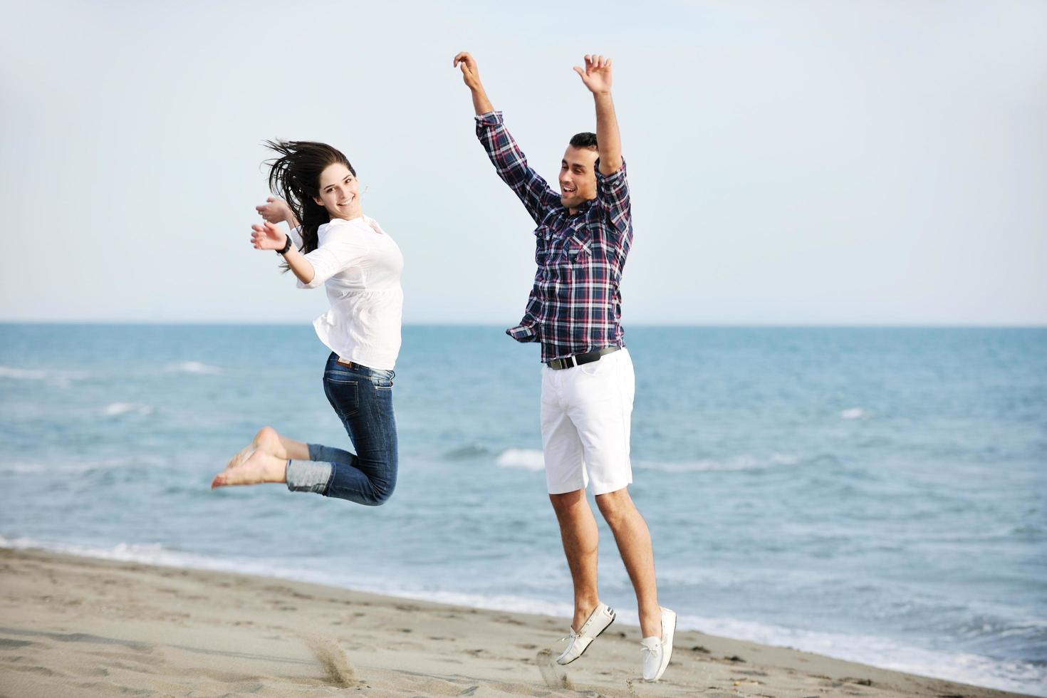 happy young couple have fun on beach photo