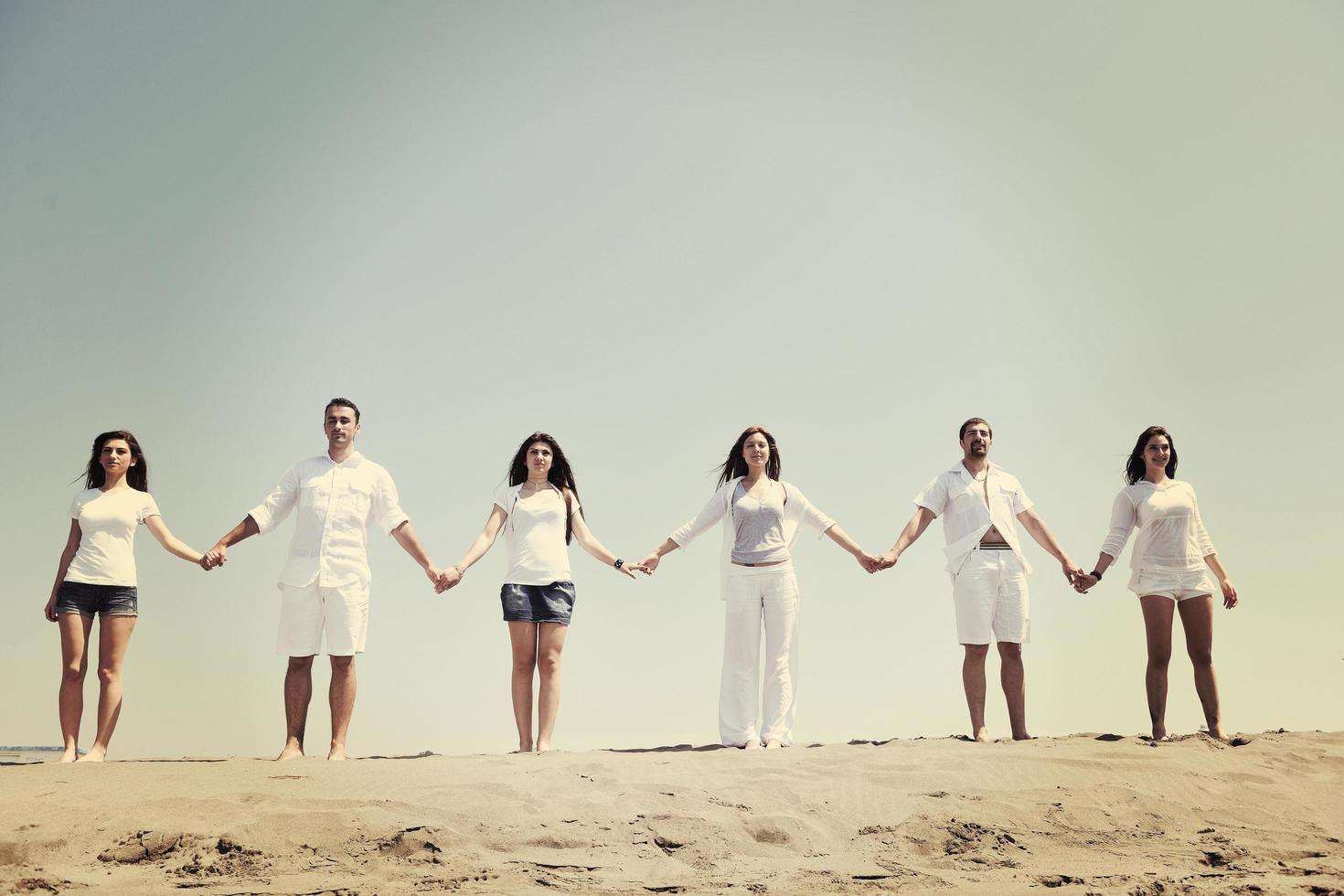 grupo de gente feliz divertirse y correr en la playa foto