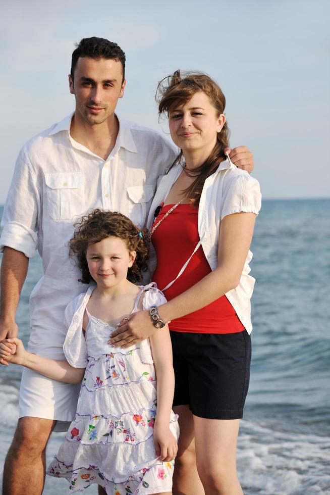 familia joven feliz divertirse en la playa foto