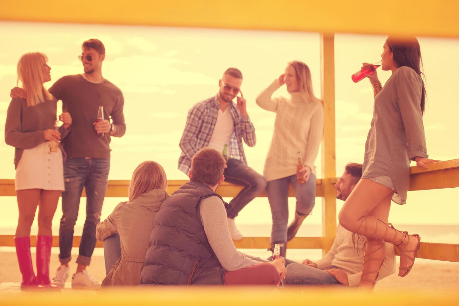 grupo de amigos divirtiéndose el día de otoño en la playa foto