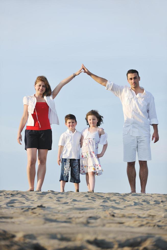 family on beach showing home sign photo