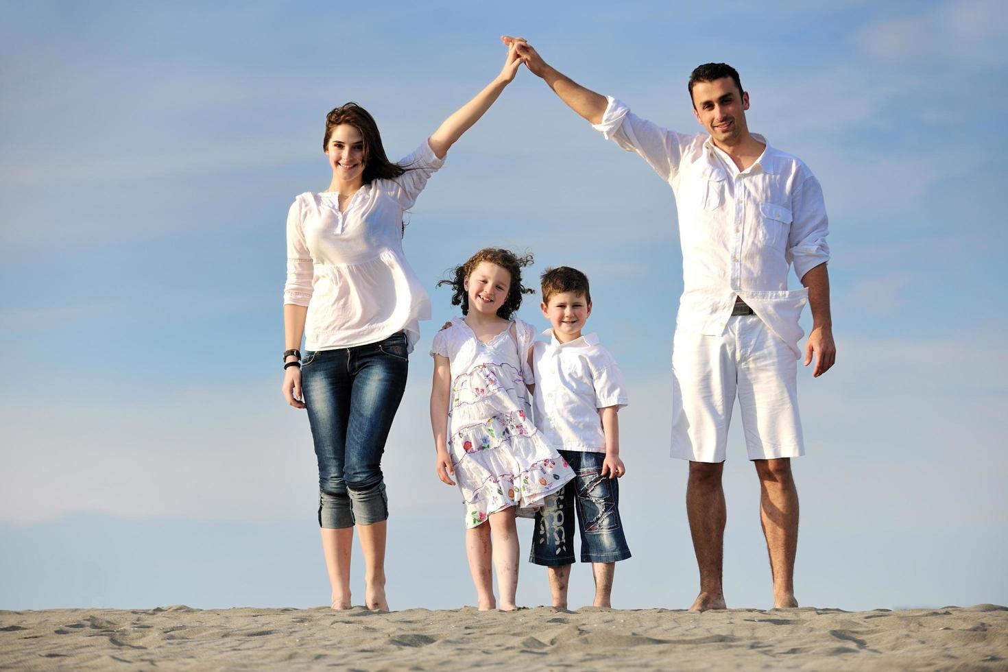 family on beach showing home sign photo