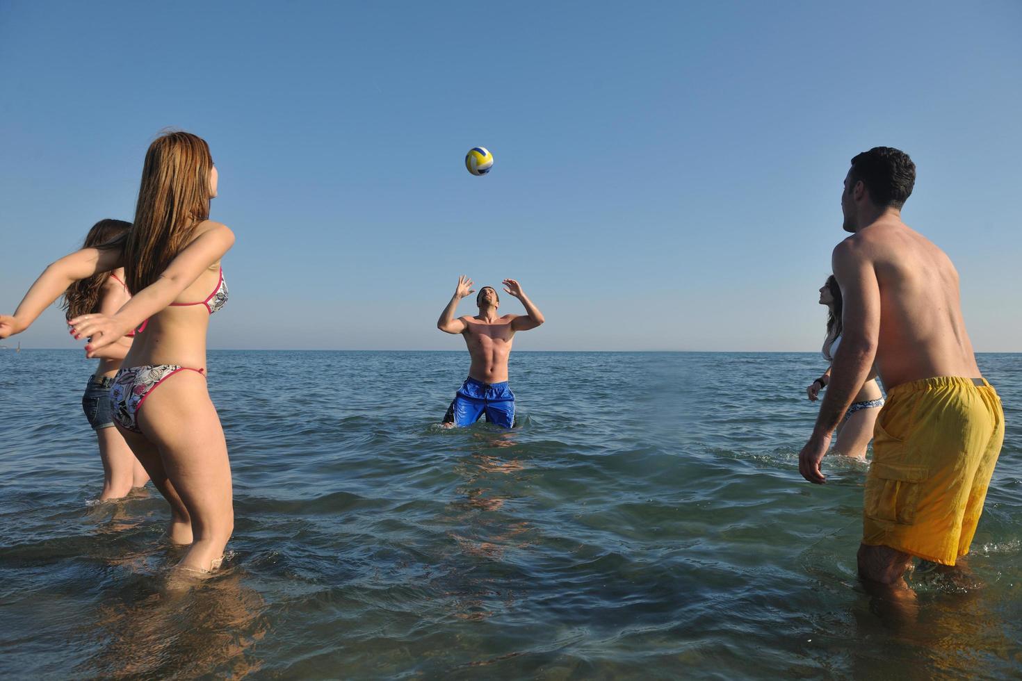 young people group have fun and play beach volleyball photo