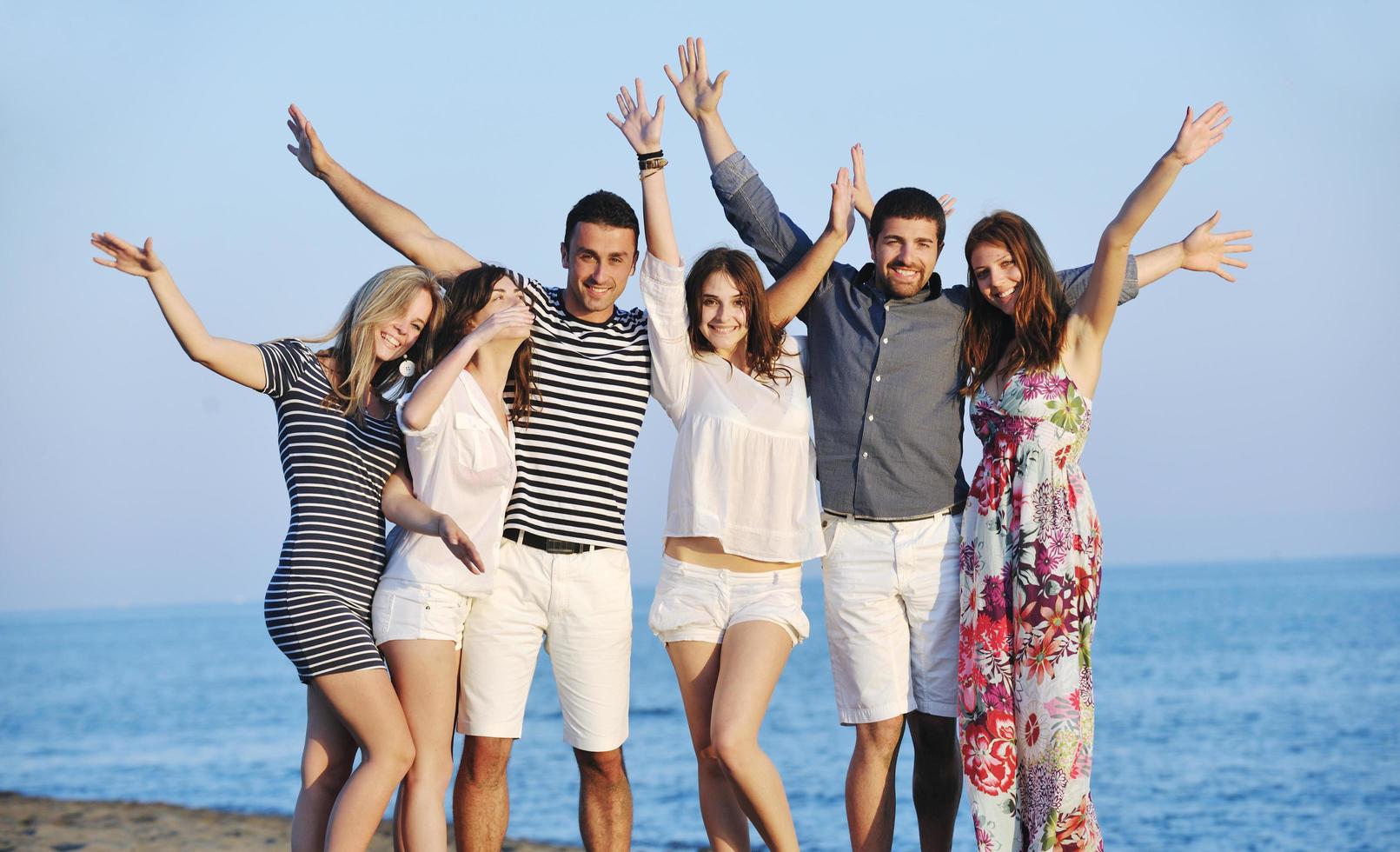 happy young  people group have fun on beach photo