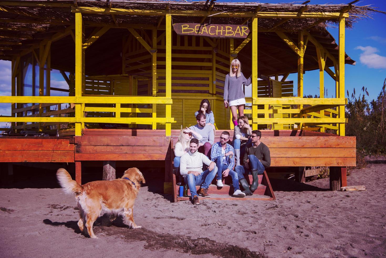 grupo de amigos divirtiéndose el día de otoño en la playa foto