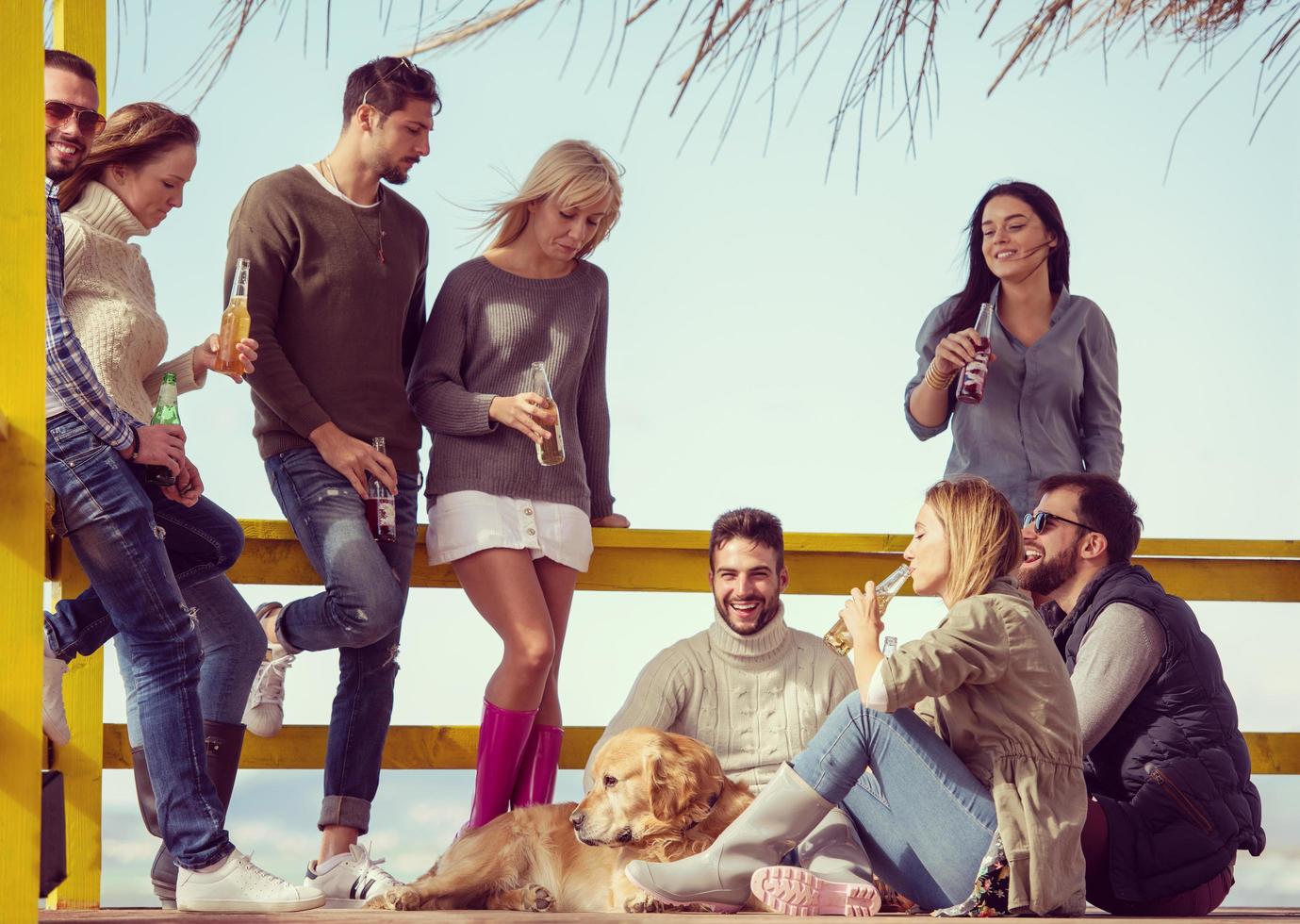 Group of friends having fun on autumn day at beach photo