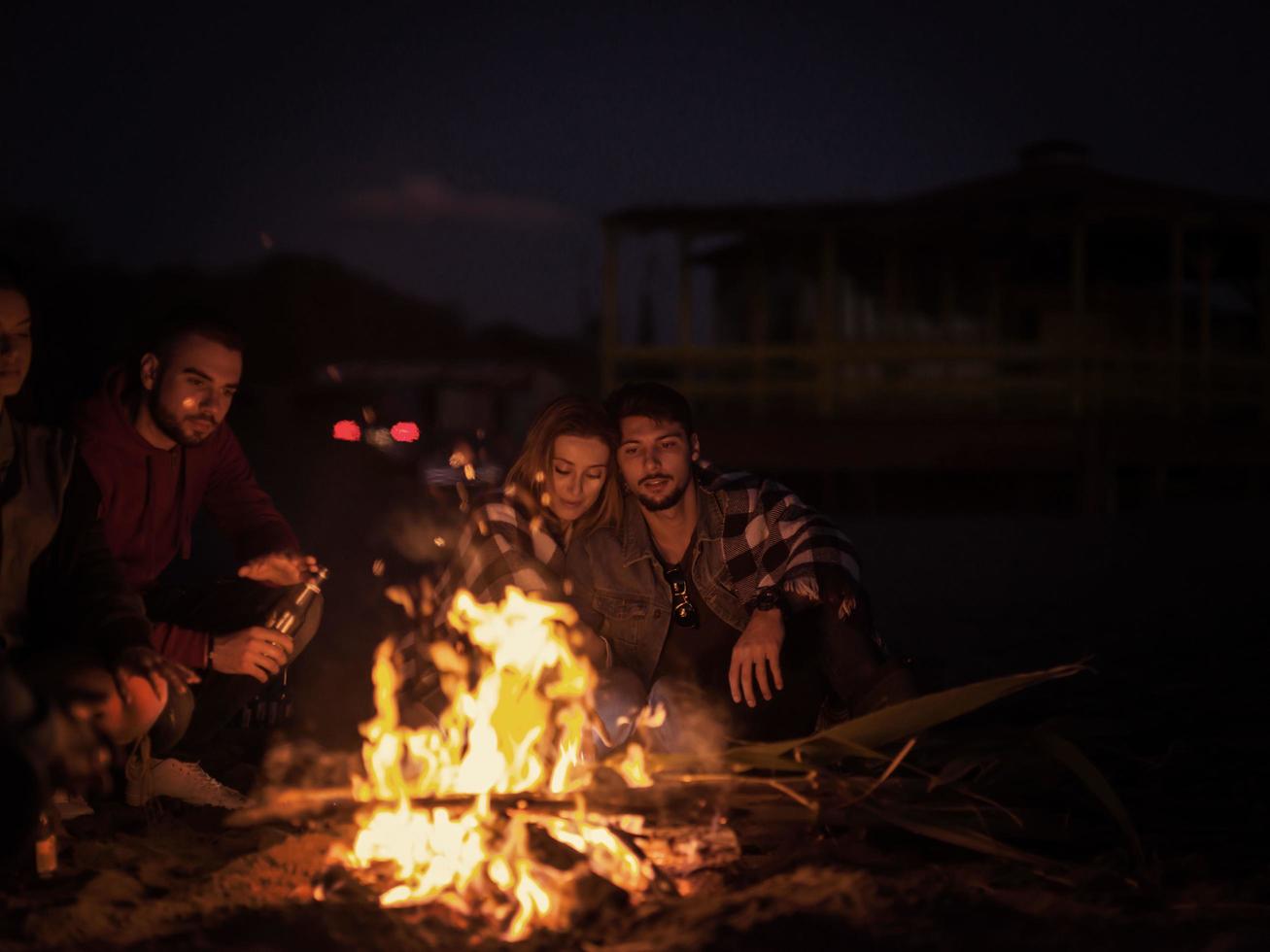 pareja disfrutando con amigos por la noche en la playa foto