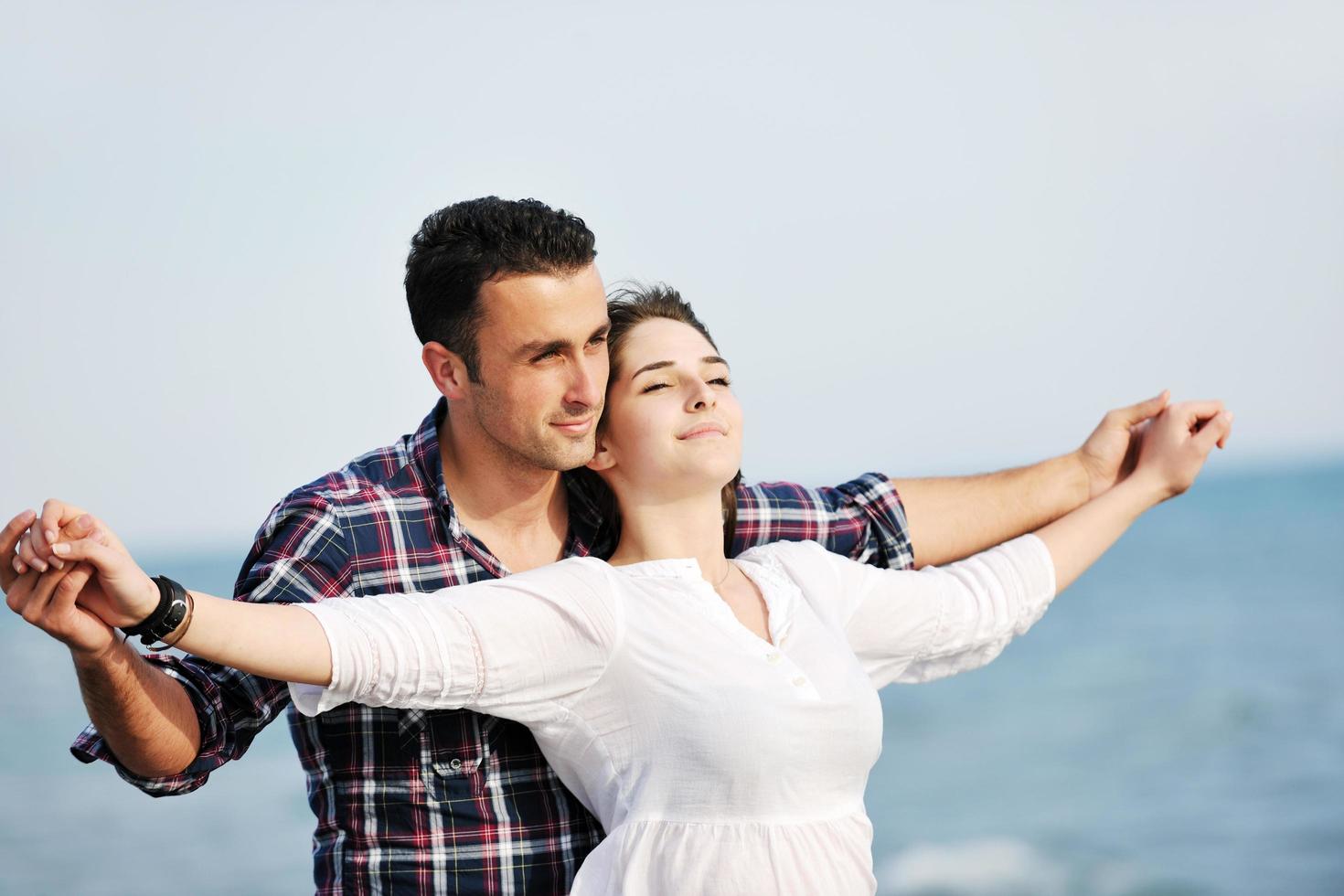 happy young couple have fun on beach photo