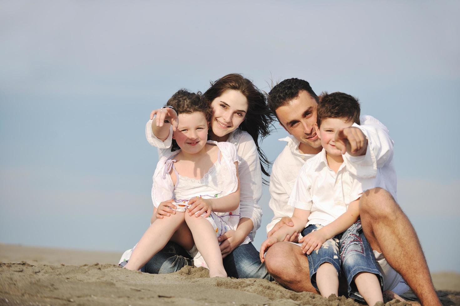 familia joven feliz divertirse en la playa foto