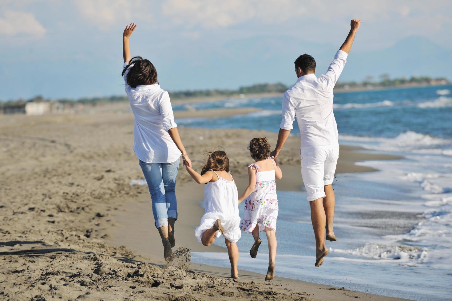 familia joven feliz divertirse en la playa foto