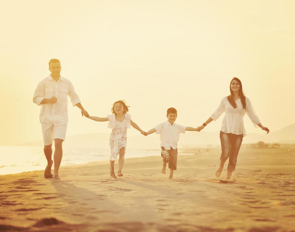 happy young family have fun on beach at sunset photo