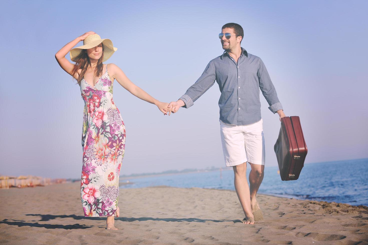 couple on beach with travel bag photo