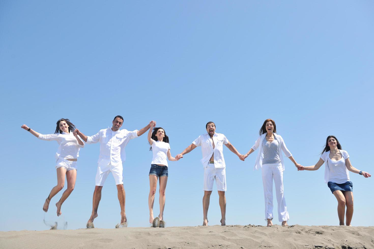 grupo de gente feliz divertirse y correr en la playa foto