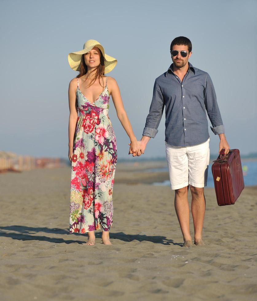 couple on beach with travel bag photo