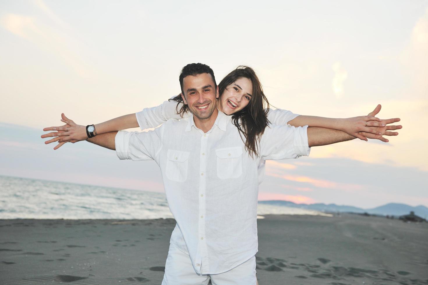 happy young couple have fun on beach photo