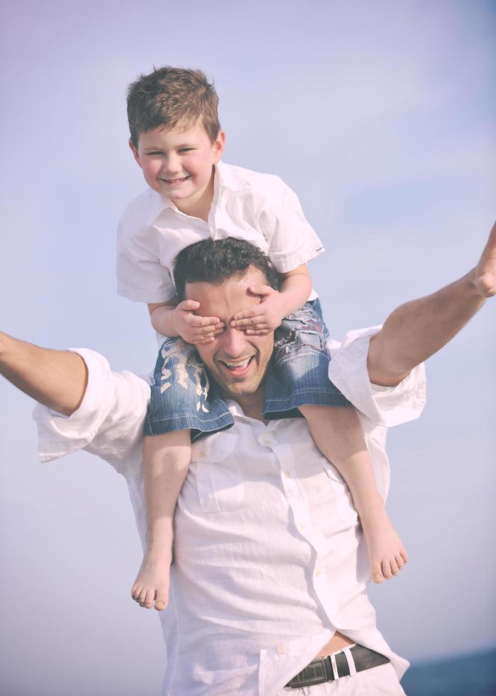 happy father and son have fun and enjoy time on beach photo