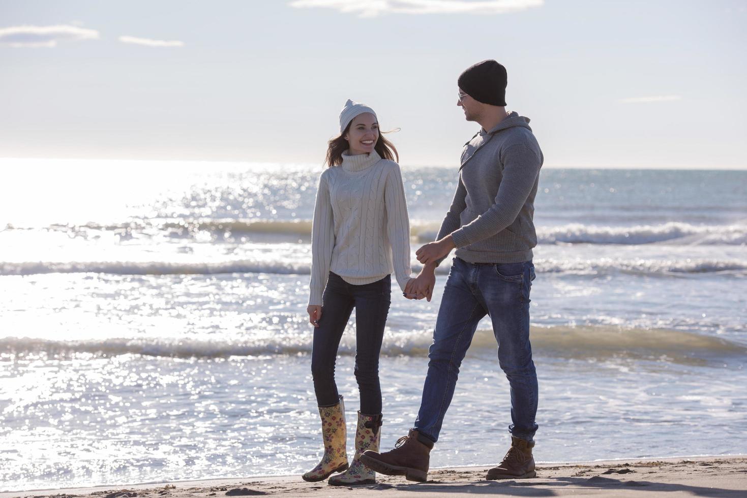 Loving young couple on a beach at autumn sunny day photo