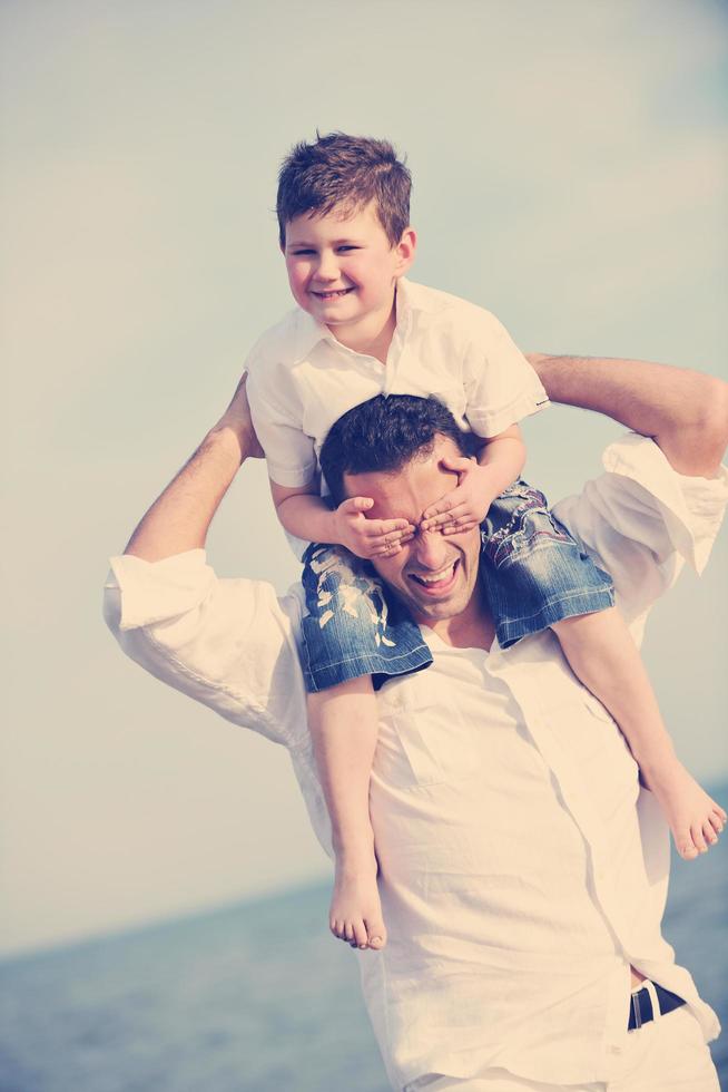 happy father and son have fun and enjoy time on beach photo