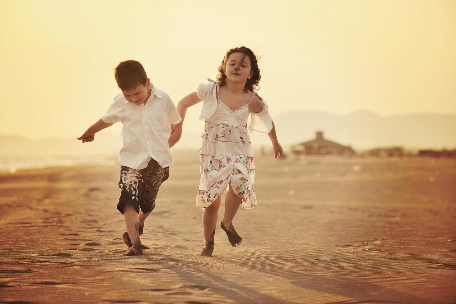 familia joven feliz divertirse en la playa al atardecer foto