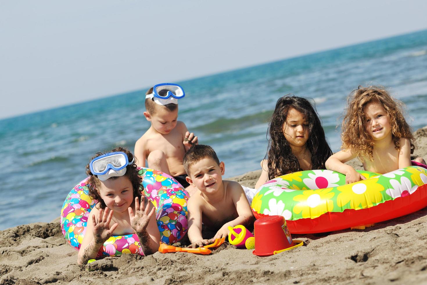 grupo infantil divertirse y jugar con juguetes de playa foto