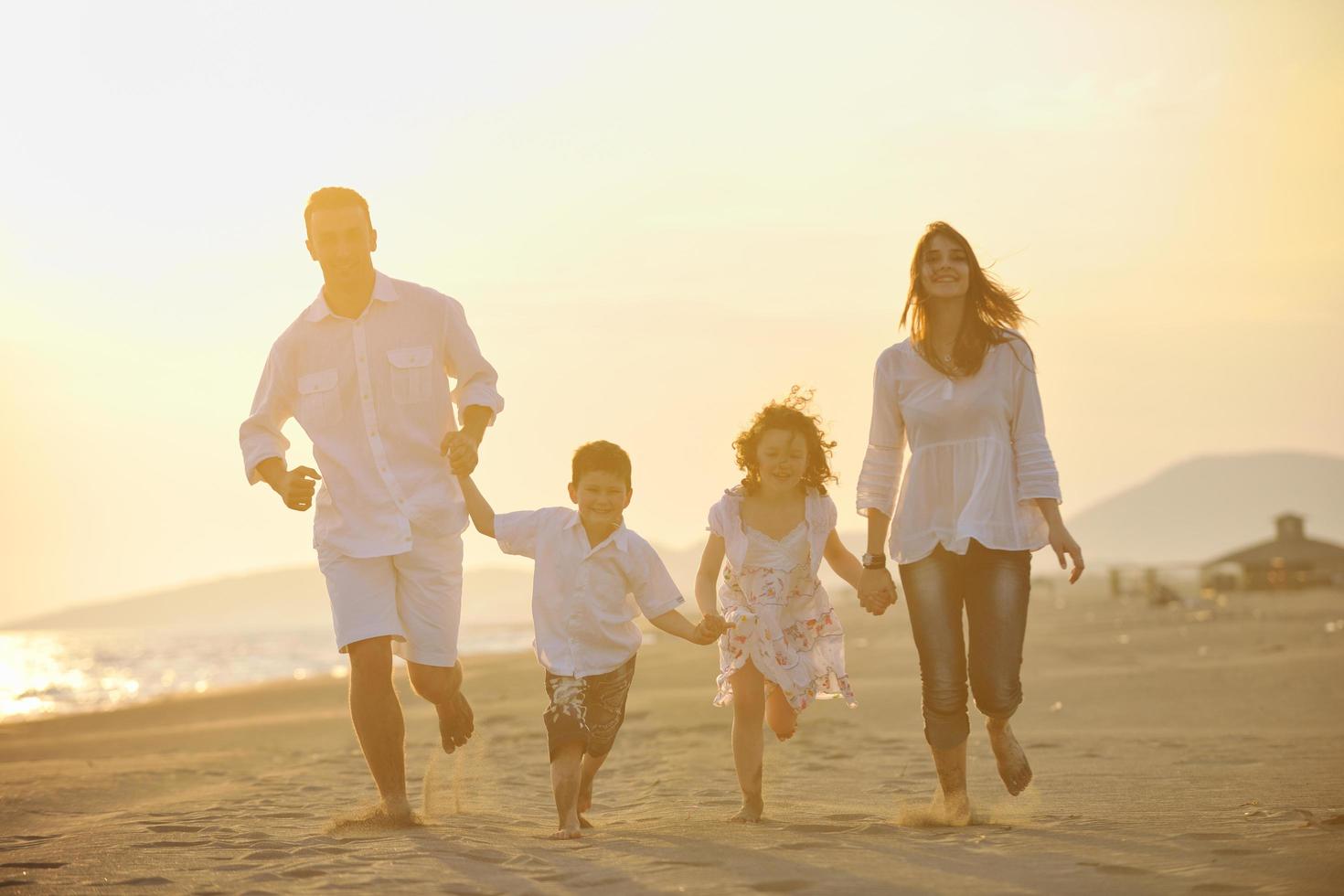 familia joven feliz divertirse en la playa foto