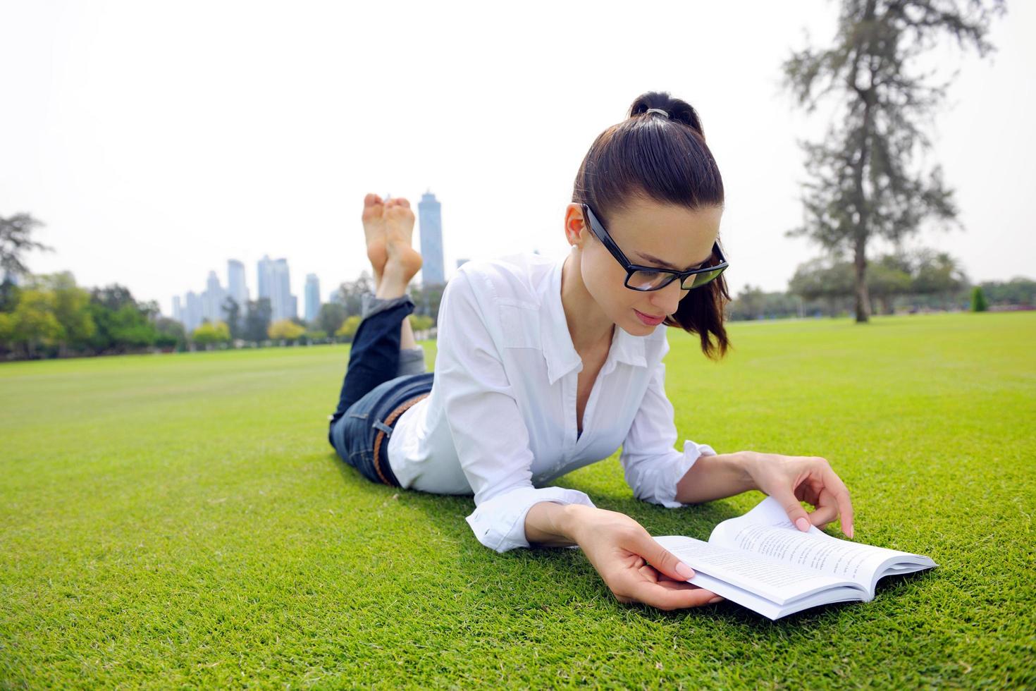 Young woman reading a book in the park photo