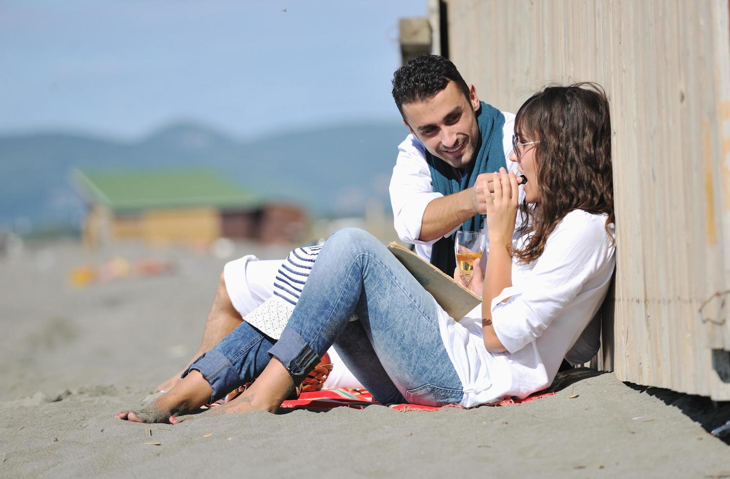 pareja joven disfrutando de un picnic en la playa foto