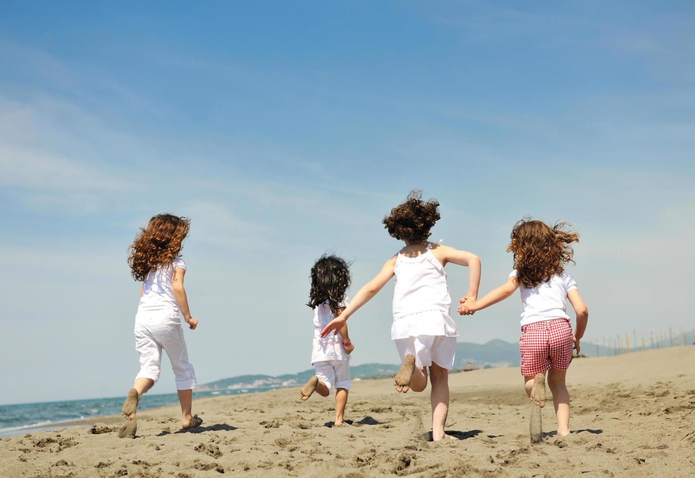 happy child group playing  on beach photo