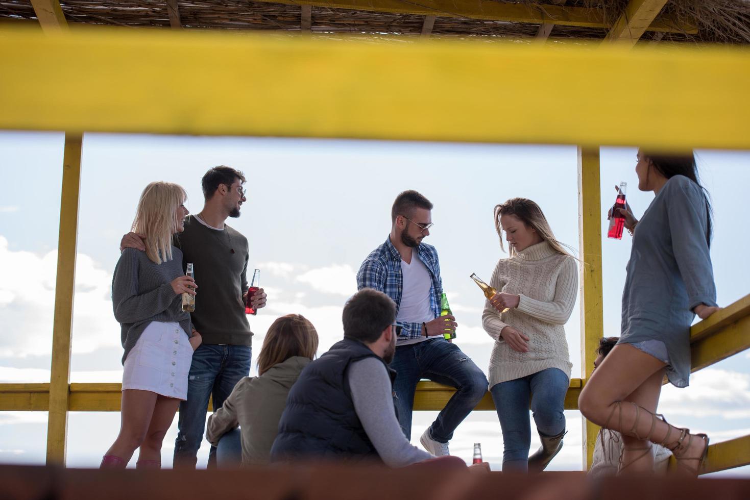 grupo de amigos divirtiéndose el día de otoño en la playa foto