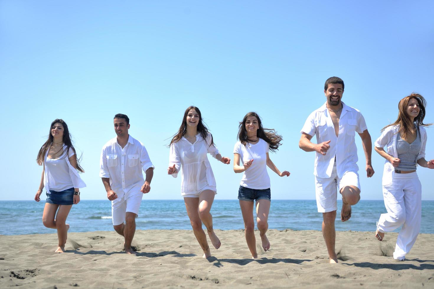 happy young  people group have fun on beach photo