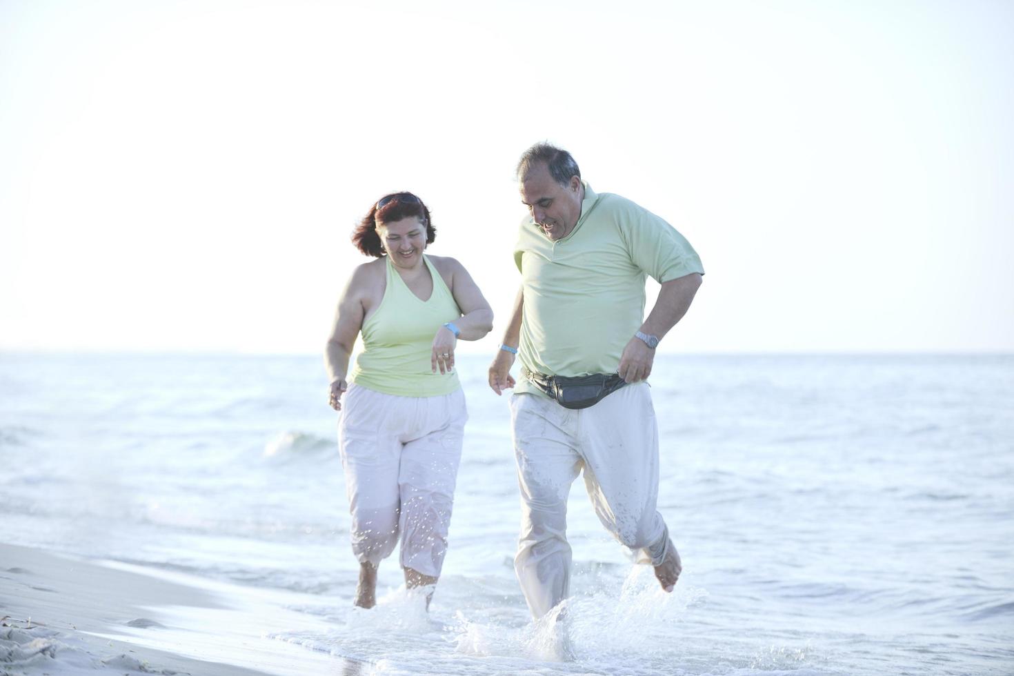 feliz pareja de ancianos en la playa foto