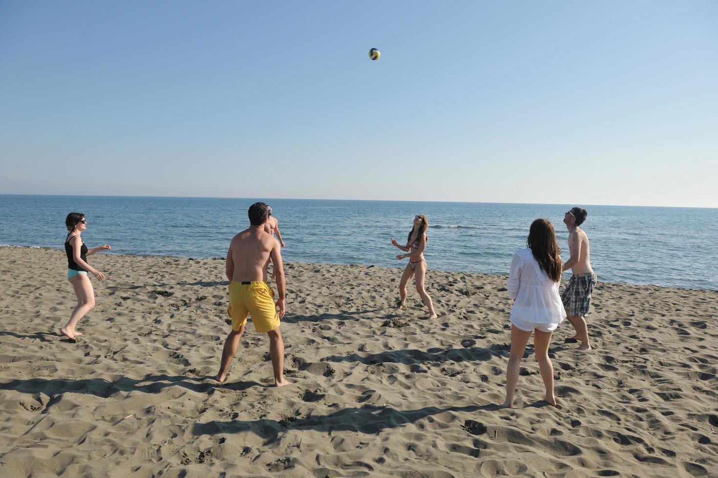 young people group have fun and play beach volleyball photo