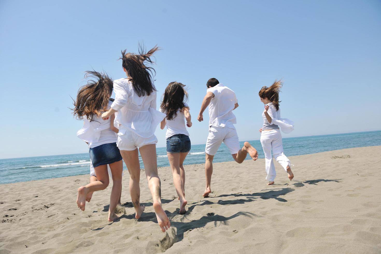 happy people group have fun and running on beach photo