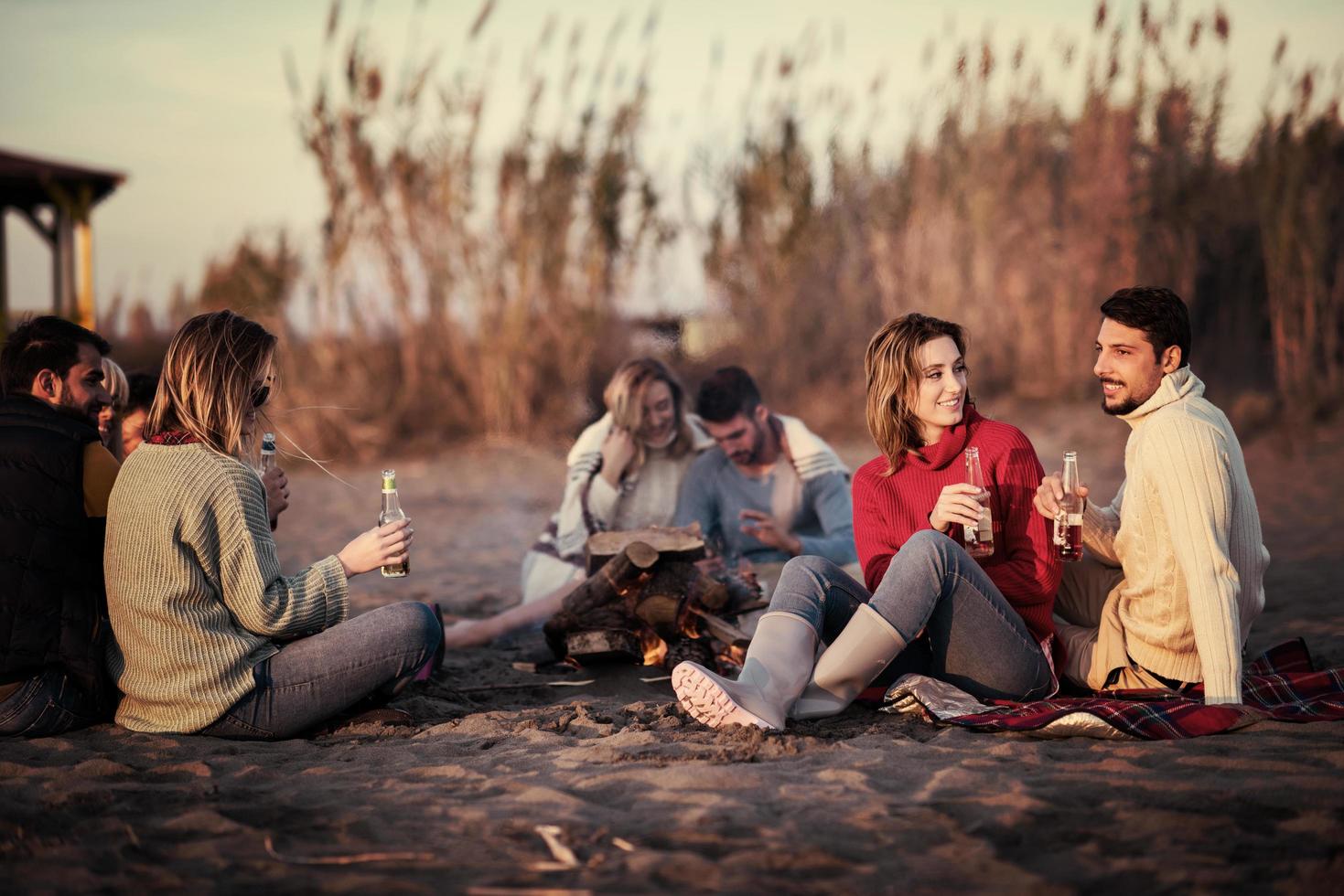 Couple enjoying with friends at sunset on the beach photo