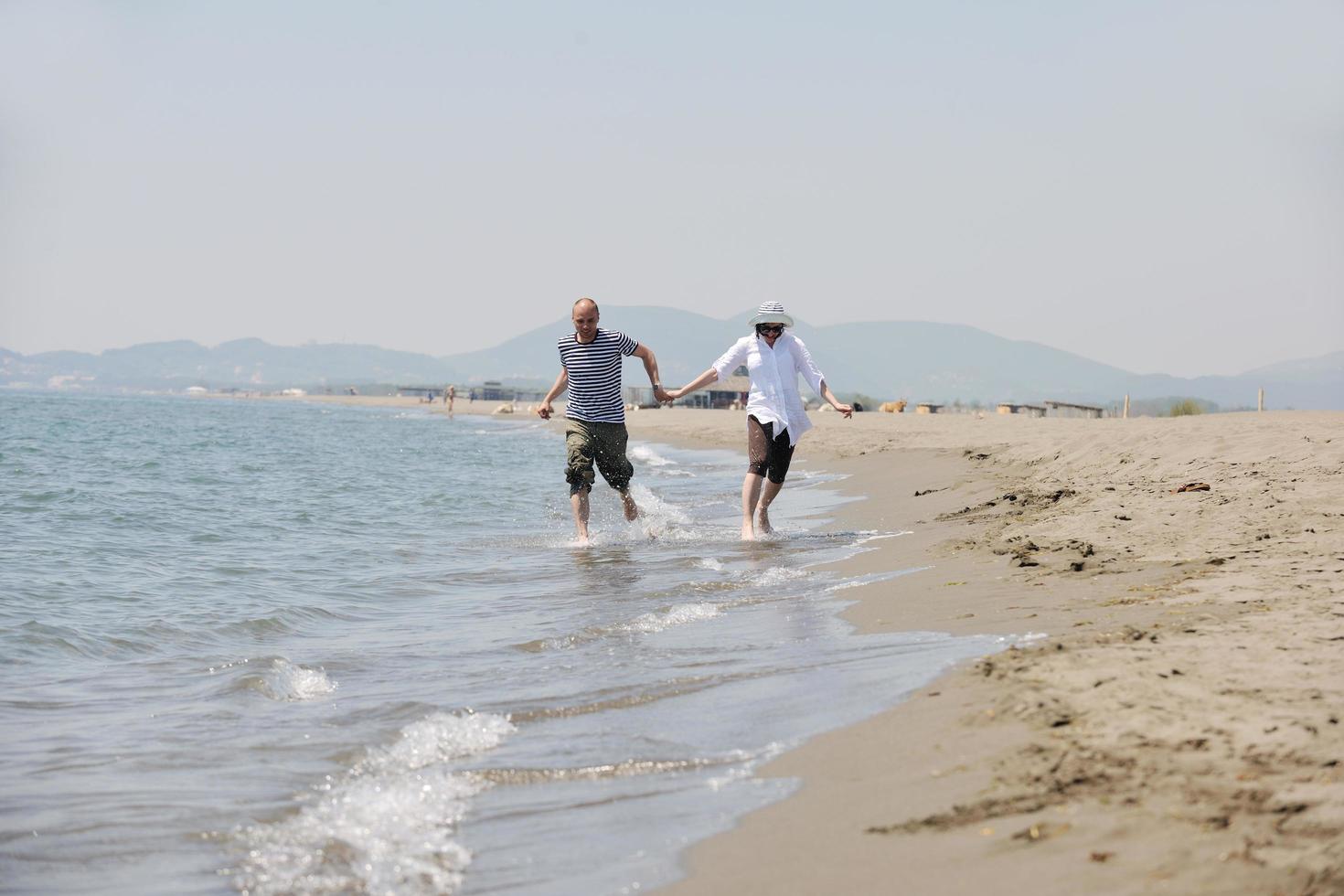 happy young couple have fun on beach photo