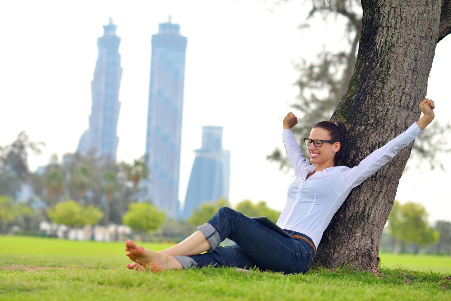 Beautiful young woman with  tablet in park photo