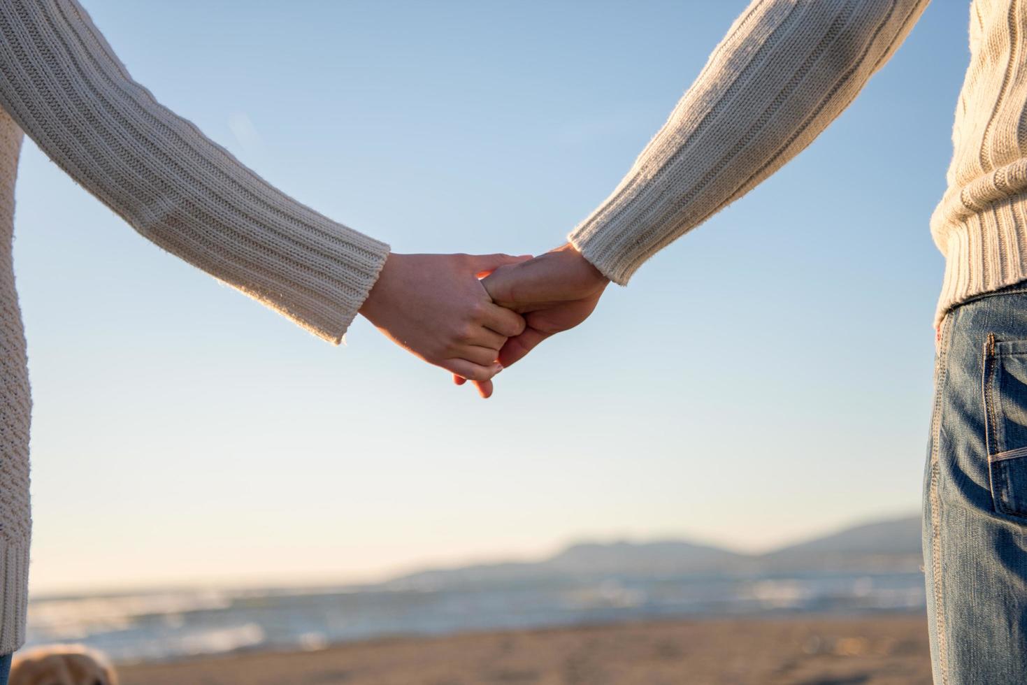 Loving young couple on a beach at autumn sunny day photo